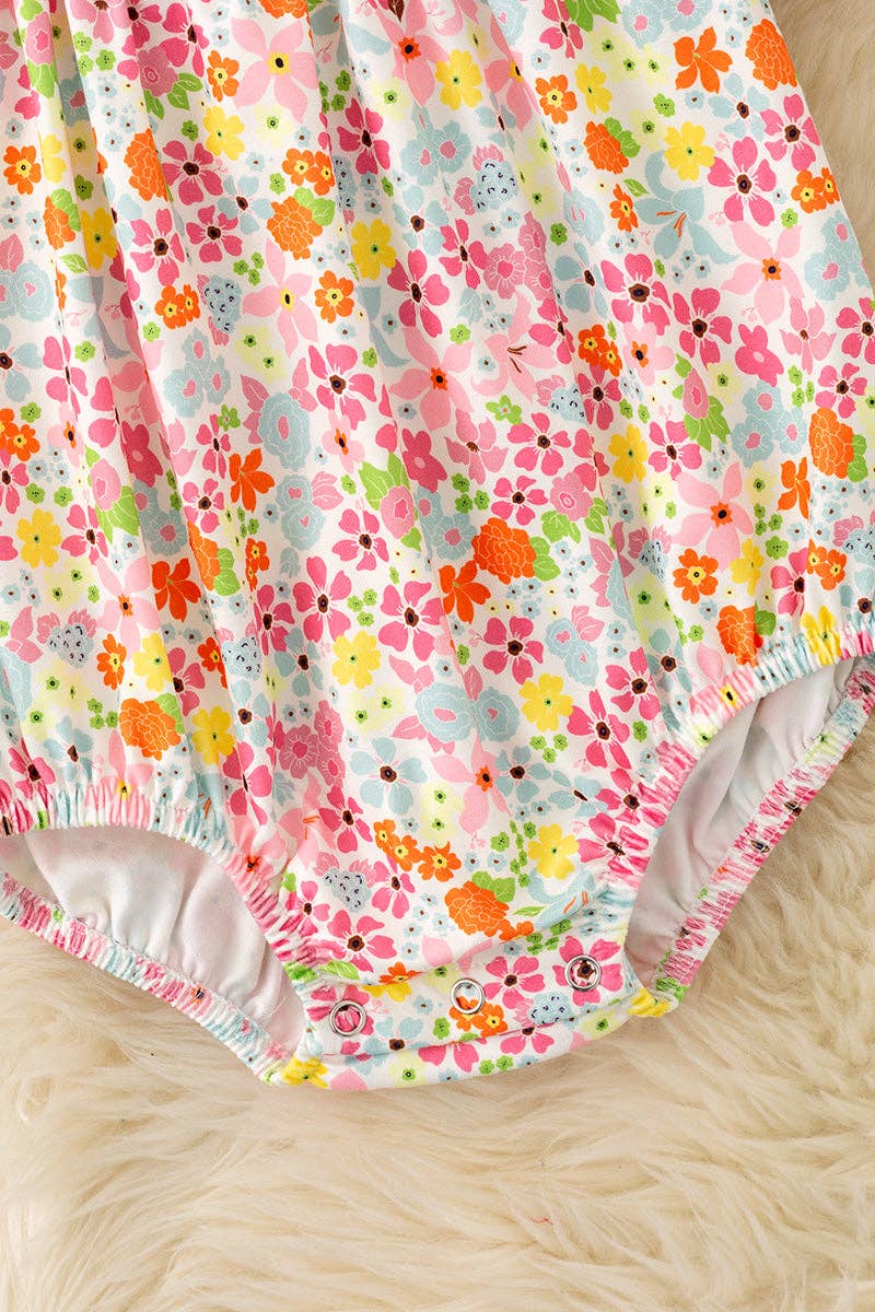 Floral smock baby romper with snaps.