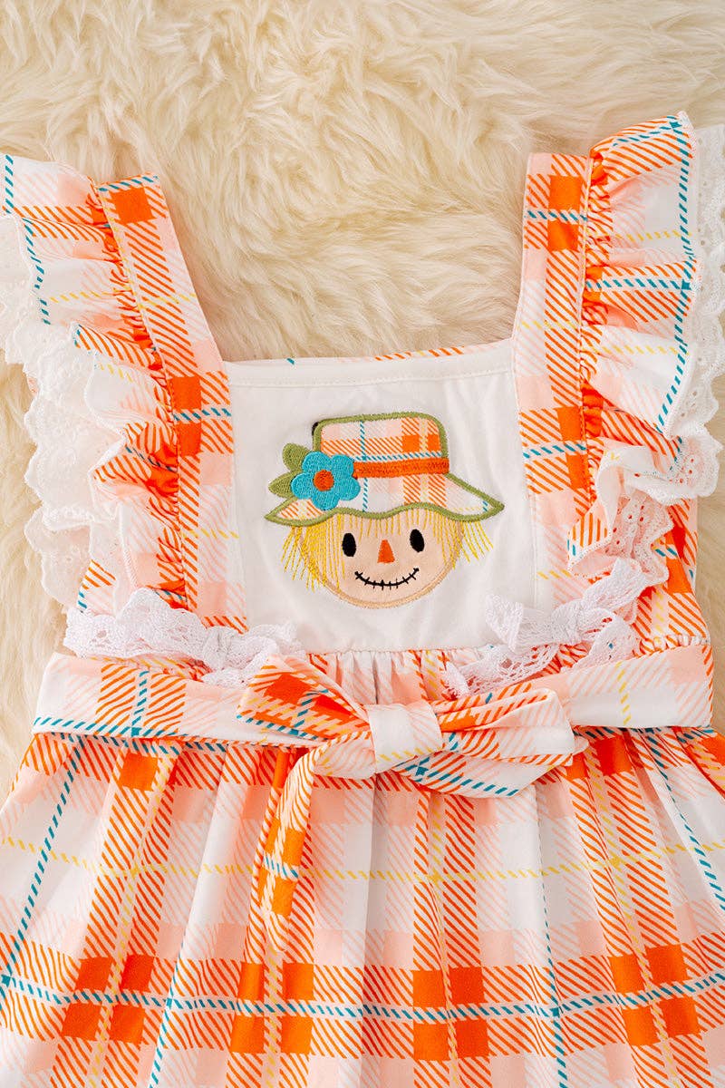 Scarecrow applique dress with embroidered hem.