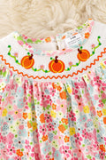 Floral smock baby romper with snaps.