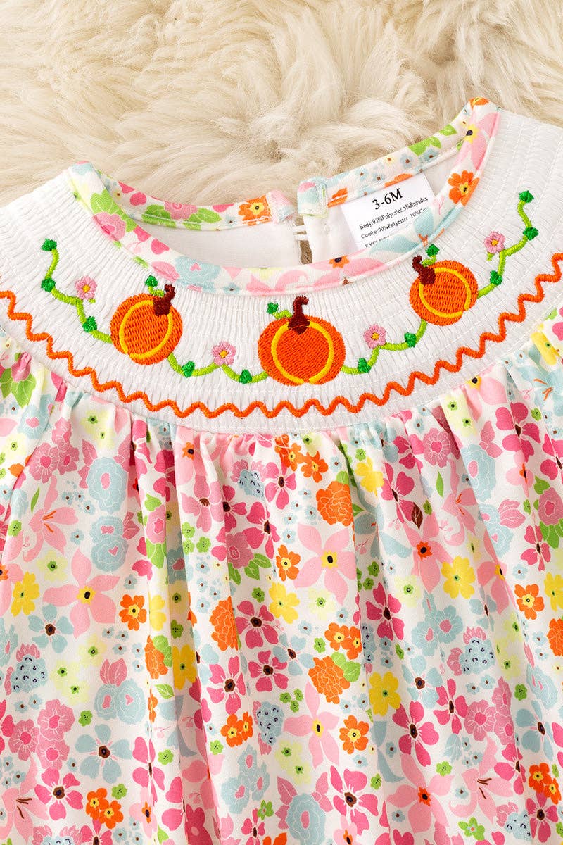 Floral smock baby romper with snaps.