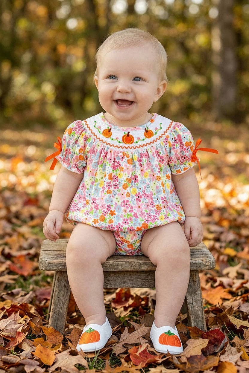 Floral smock baby romper with snaps.
