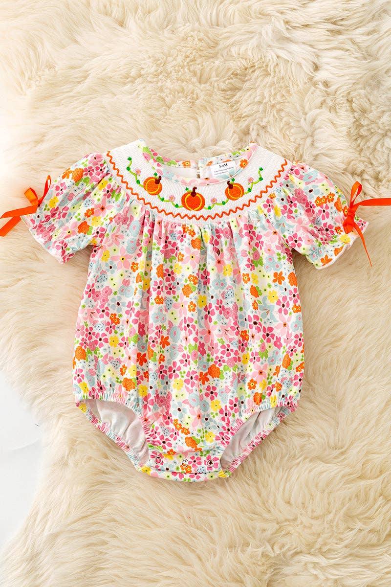 Floral smock baby romper with snaps.