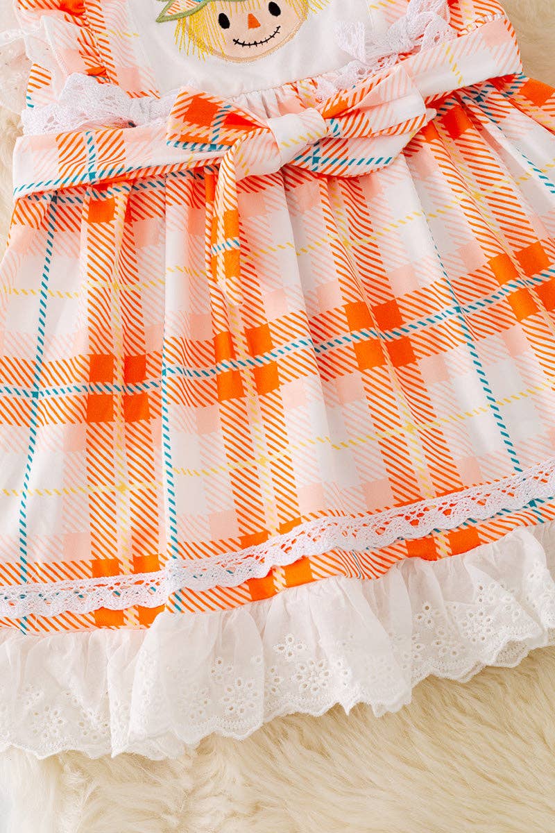 Scarecrow applique dress with embroidered hem.