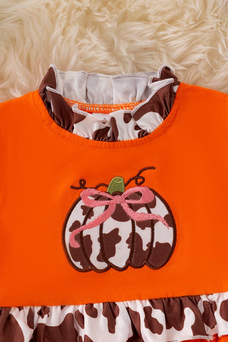 Cow printed pumpkin baby bodysuit .