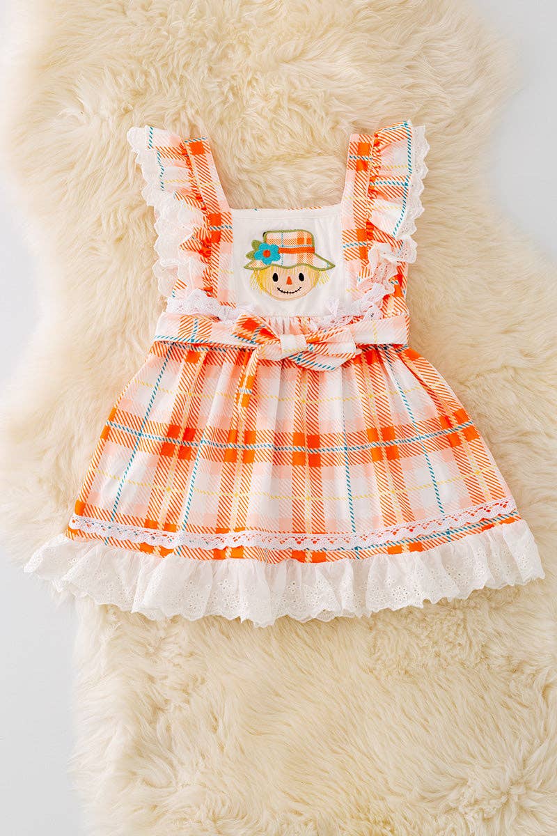 Scarecrow applique dress with embroidered hem.